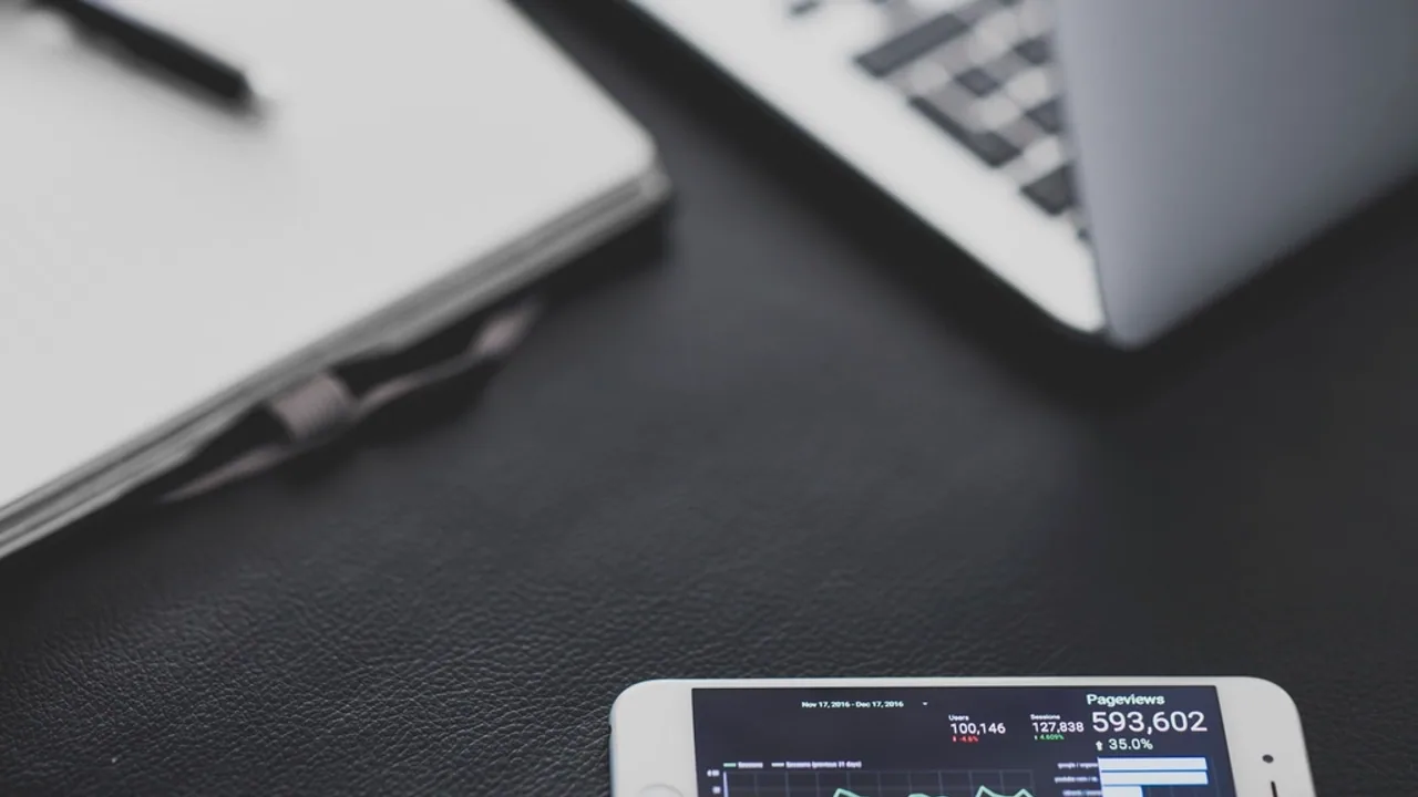 Laptop and smartphone analytics dashboard on a clean desk